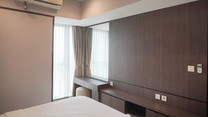 Ein Hotelzimmer mit einem großen Bett, einem Schreibtisch und einem Kleiderschrank.