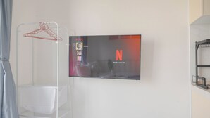 A wall-mounted television displaying the Netflix interface with a profile named "Anton" and a notification that the profile lock is on. - Comfy And Best Deal Studio Sky House Bsd Apartment Near Aeon (Pagedangan)