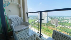 A balcony with a view of a cityscape, including high-rise buildings and a road. - Comfort And Good Place Studio At Sky House Bsd Apartment (Pagedangan)