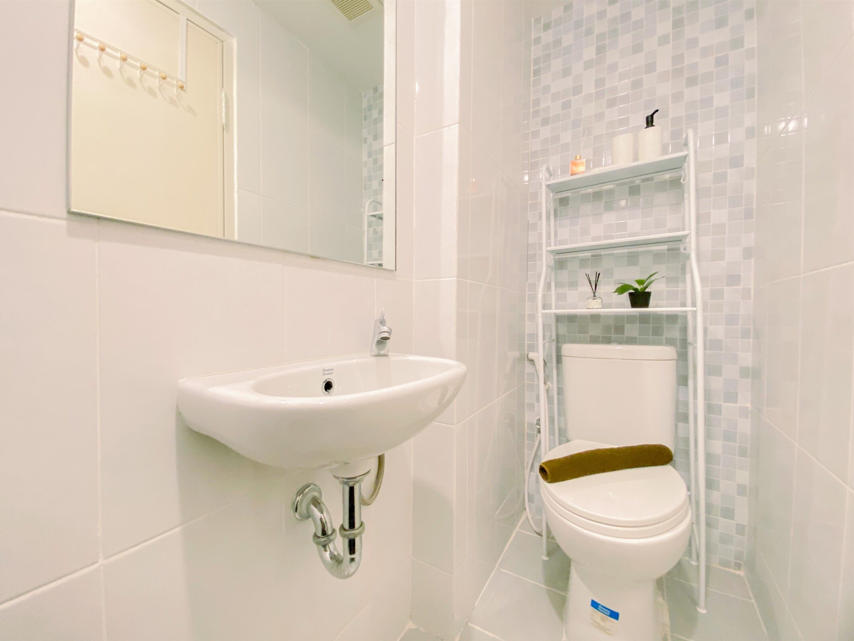 A bathroom with a white sink, a toilet, and a mirror.