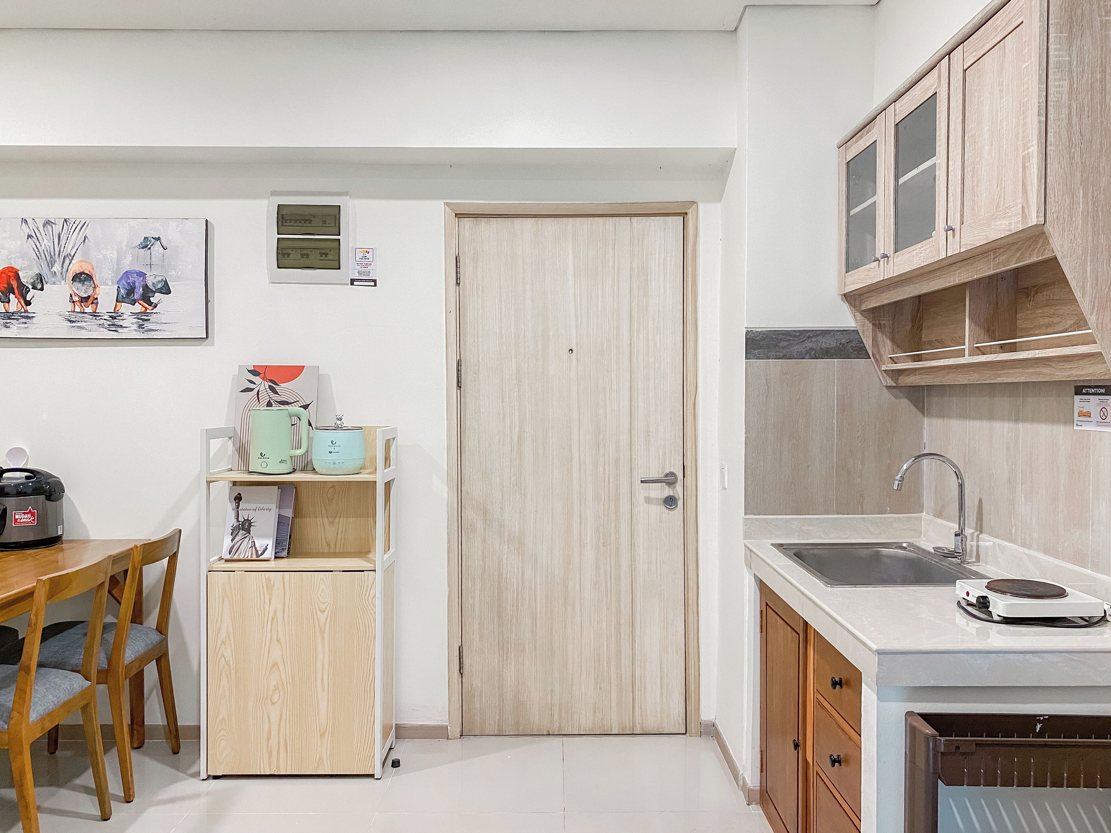 A compact kitchen with a wooden door, a sink, and a countertop.