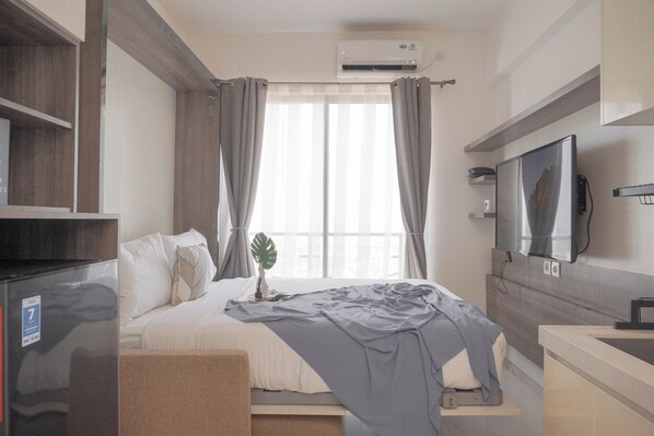 Relax in this inviting hotel room with a comfortable bed, flat-screen TV, and cozy seating area.