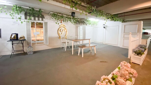An indoor space with a white table and chairs, a decorative letter 'P' on the wall, and a flower arrangement. - Restful And Tidy Studio At Paltrow City Apartment (Semarang)