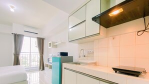 Una cocina moderna con armarios blancos, horno empotrado y microondas.