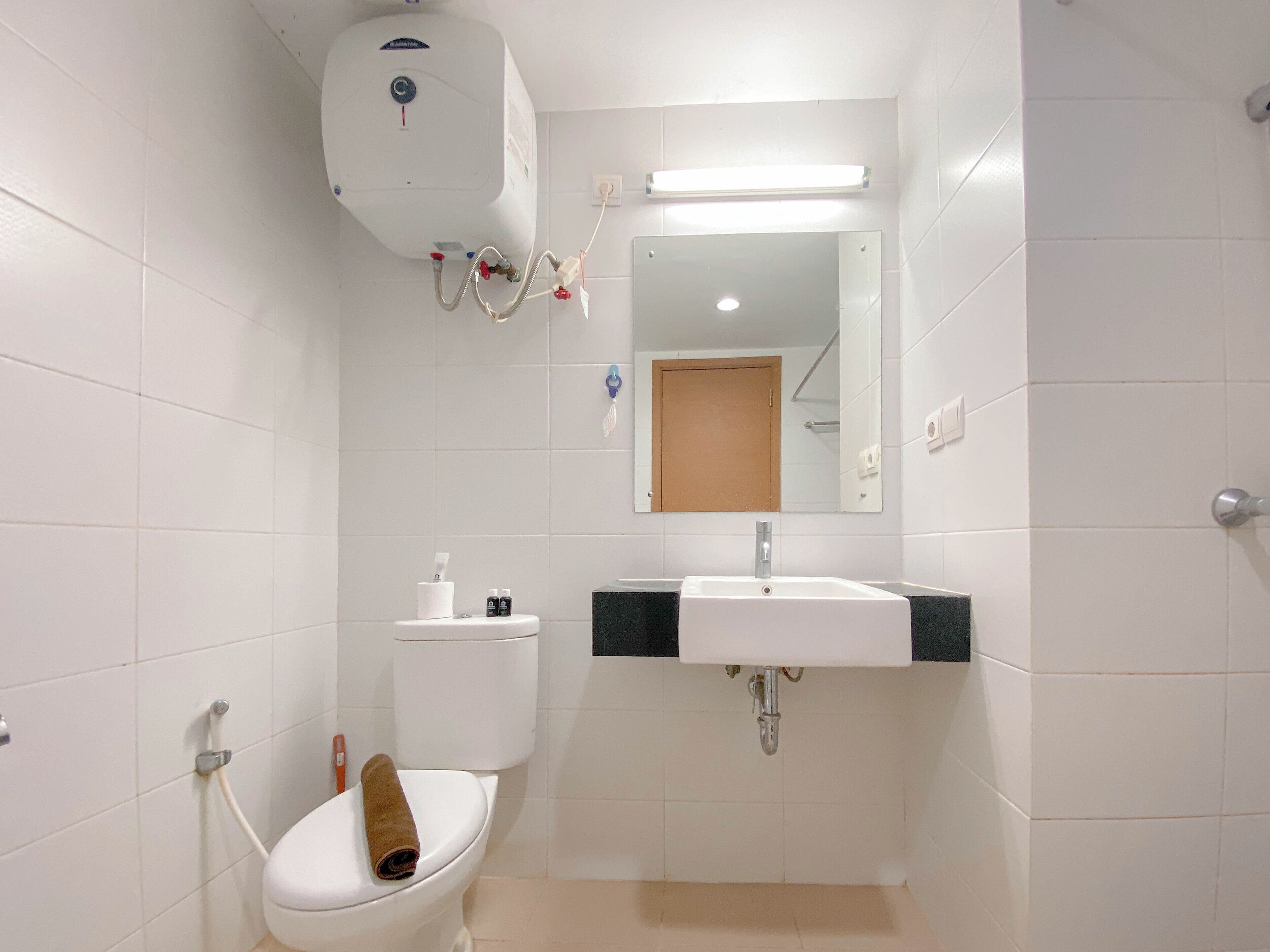 Un baño pequeño y limpio con inodoro, lavabo y espejo.