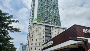 Un edificio de varios pisos con un McDonald's Drive Thru y una tienda Pop! en la planta baja.