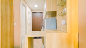 A narrow hallway with wooden walls and a door at the end. - Nice Studio At Parkland Avenue Apartment (South Tangerang)