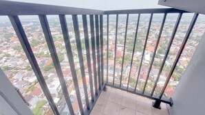 A balcony with a metal railing overlooking a cityscape. - Good Studio And Comfortable 1Br At Tamansari Bintaro Mansion Apartment (South Tangerang)