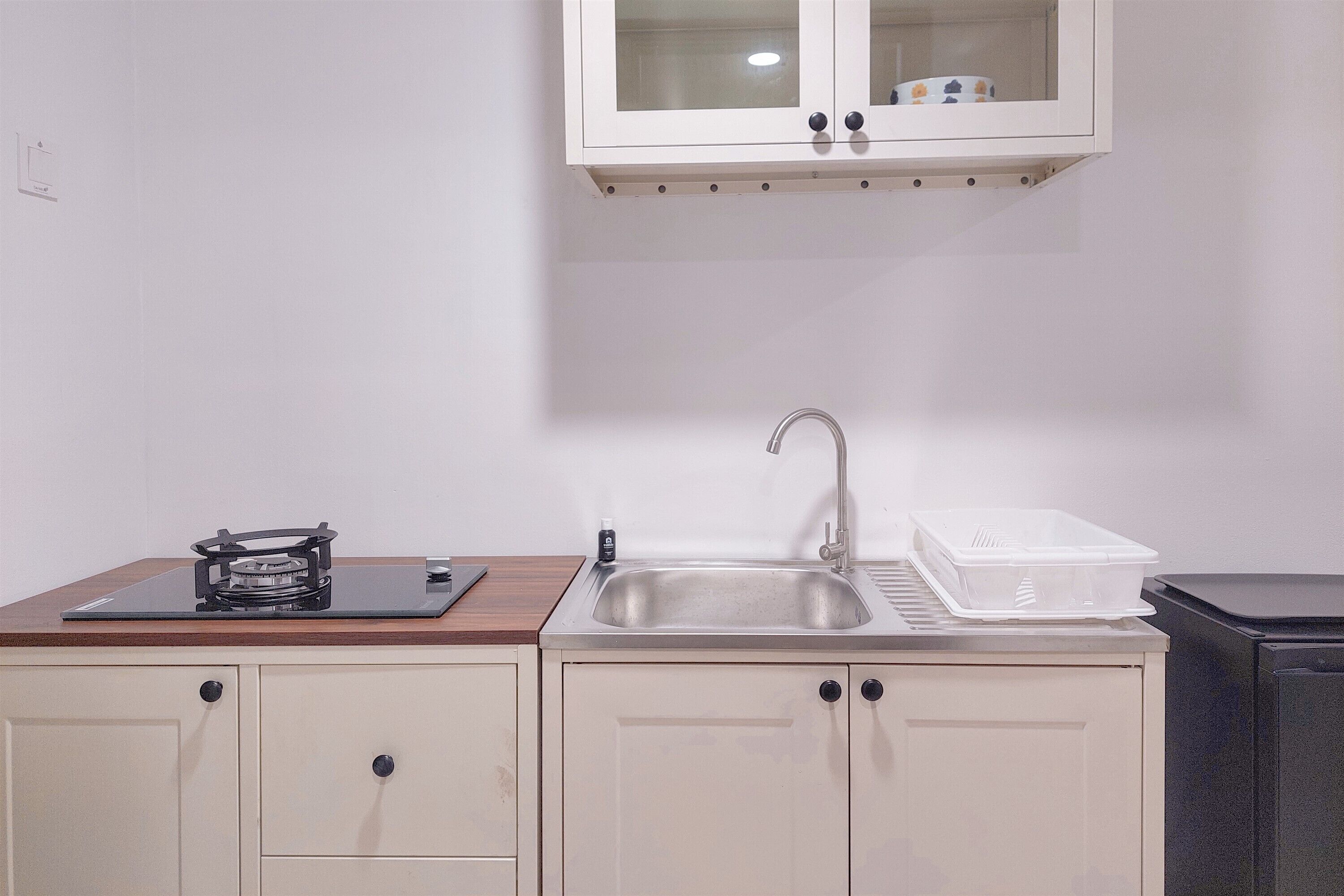A kitchen with a stove, sink, cabinets, and a microwave.