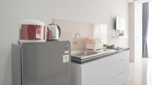 Eine moderne Küche mit Kühlschrank, Wasserkocher und Spüle.