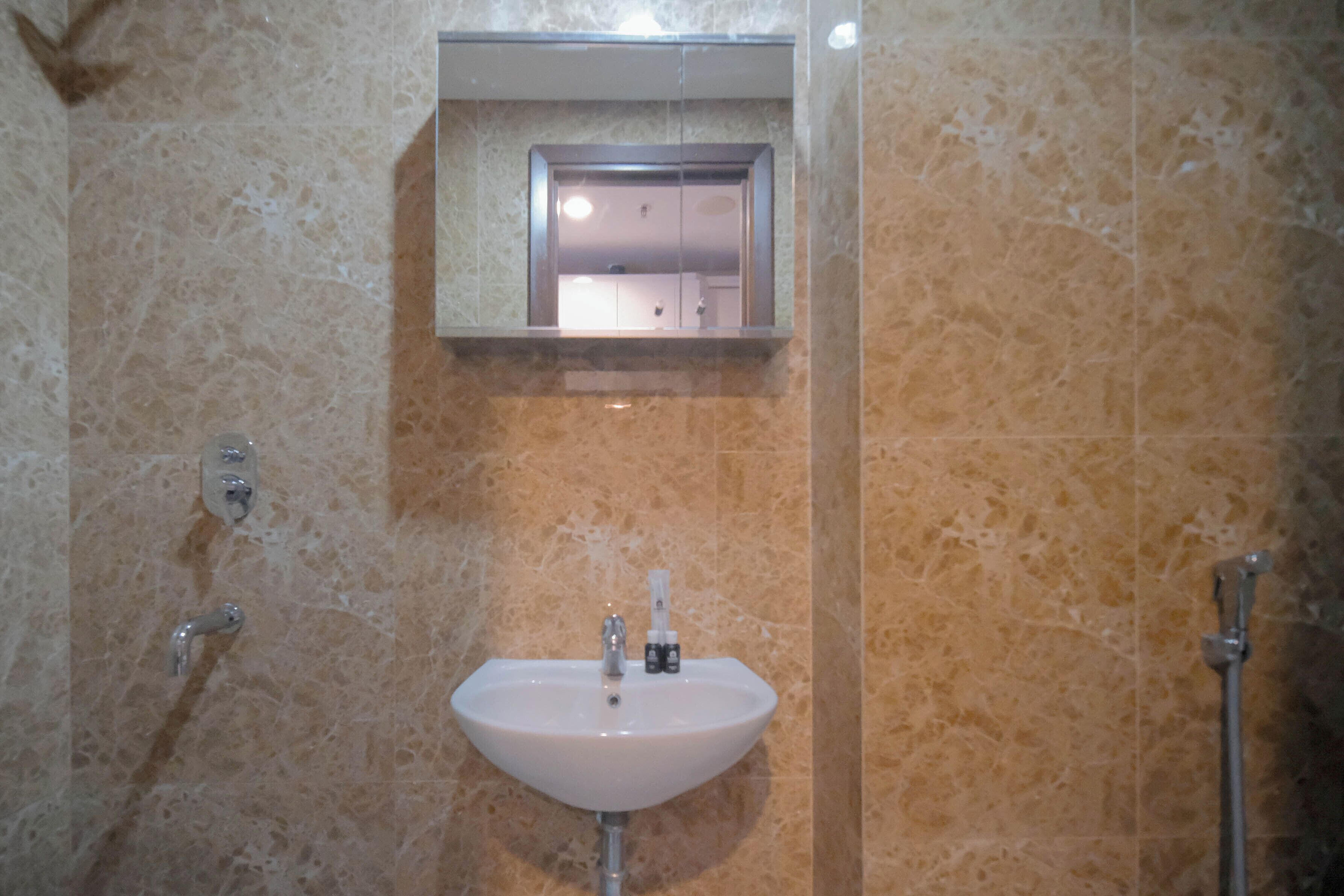 A bathroom with a sink, mirror, and shower.
