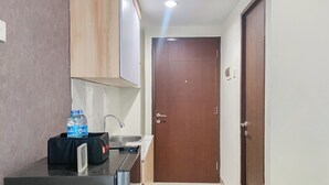 Una cocina compacta con refrigerador, lavamanos y un armario.