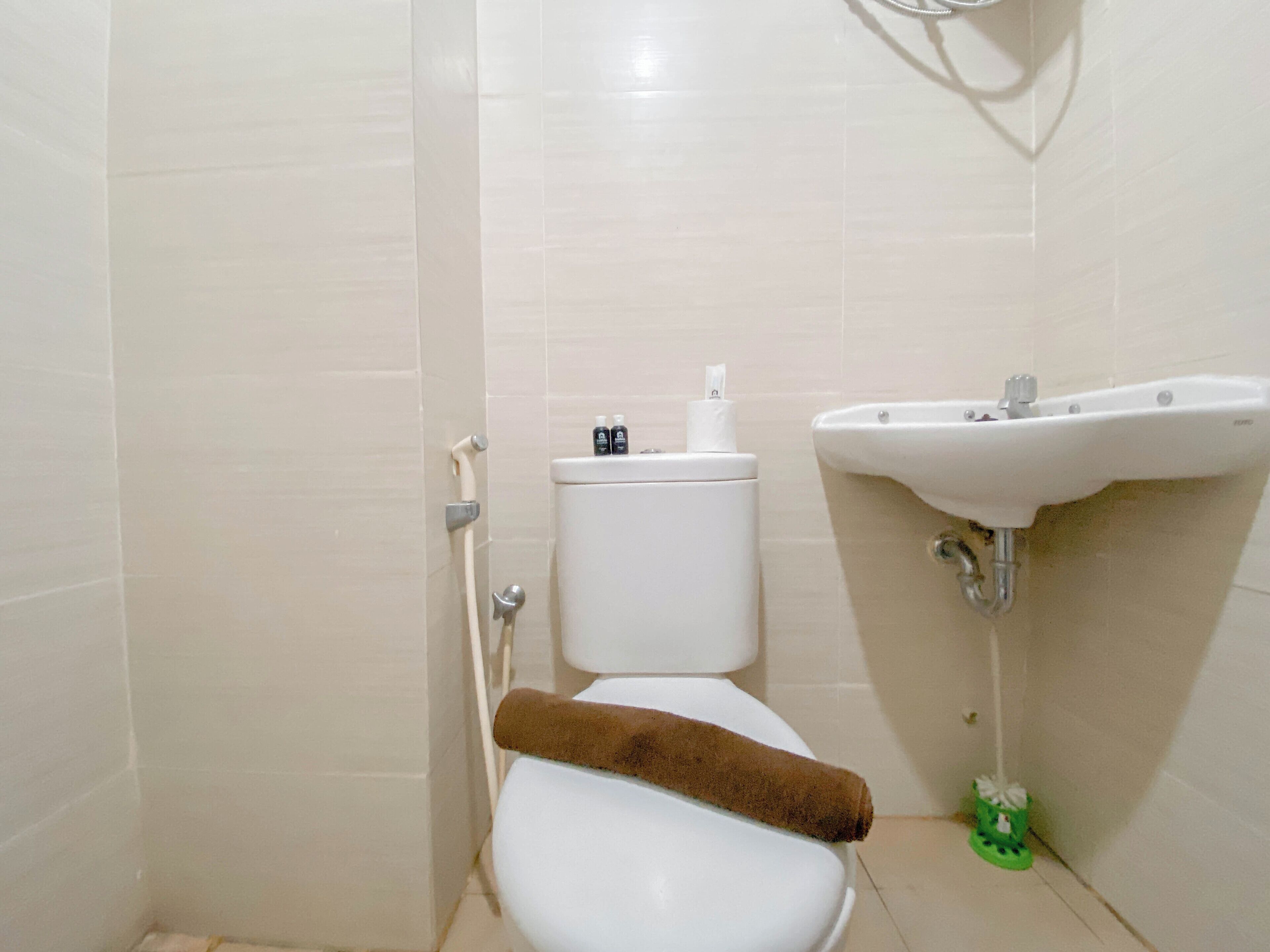A small bathroom with a toilet, a sink, and a shower.