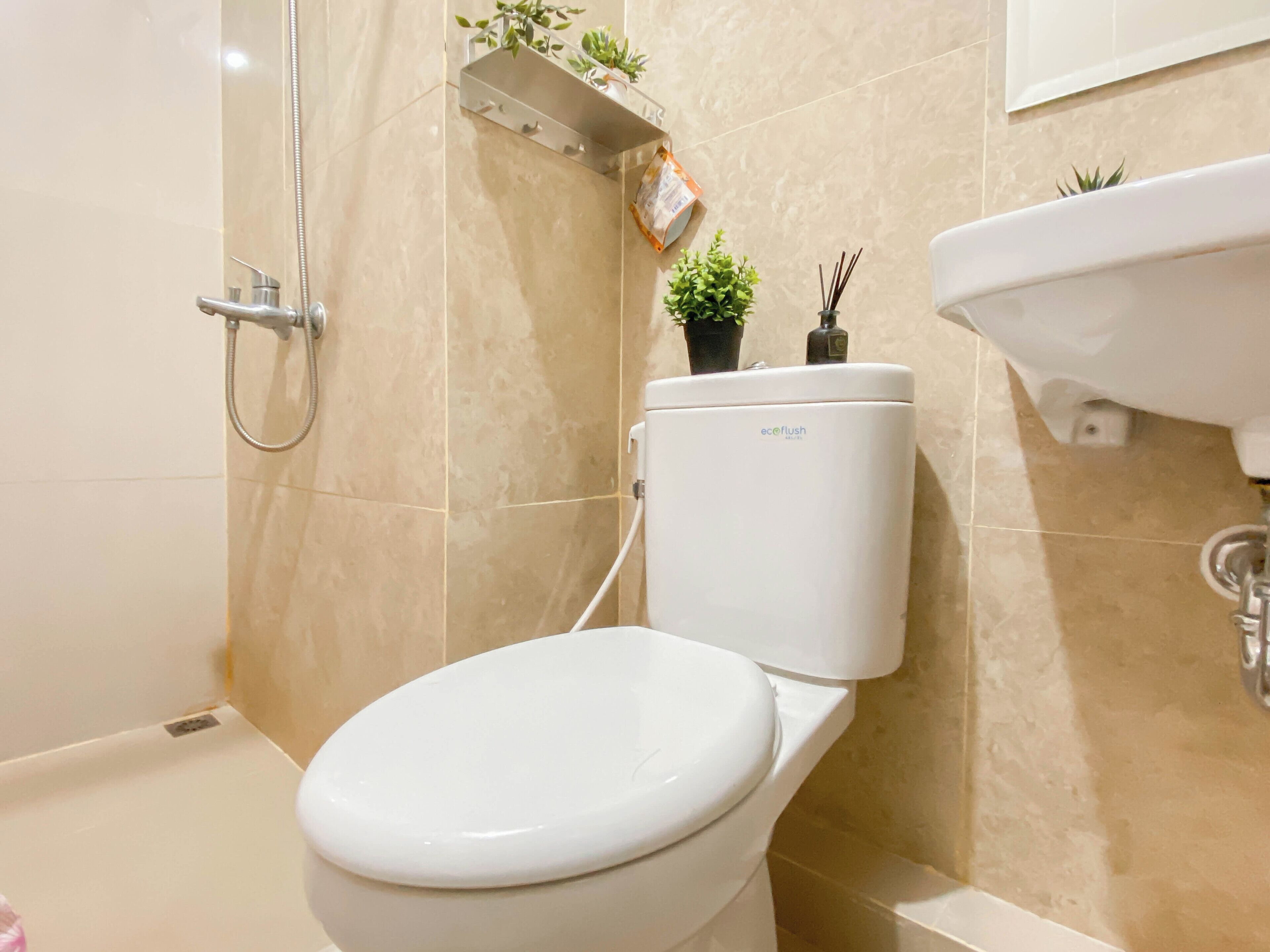 A bathroom with a toilet, a shower, and a sink.