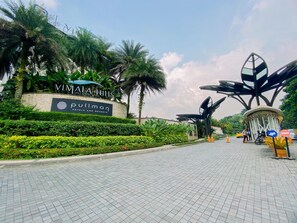 A paved pathway leading to a hotel entrance with a sign for Pullman Hotels and Resort. - Vimala Hills Villa Gadog Puncak 3Br For 12 Pax (Ciawi)