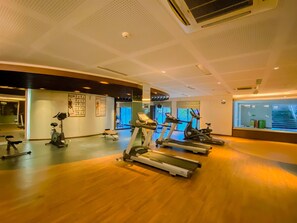 A gym with treadmills, stationary bikes, and a mirrored wall. - Vimala Hills Villa Gadog Puncak 3Br For 12 Pax (Ciawi)