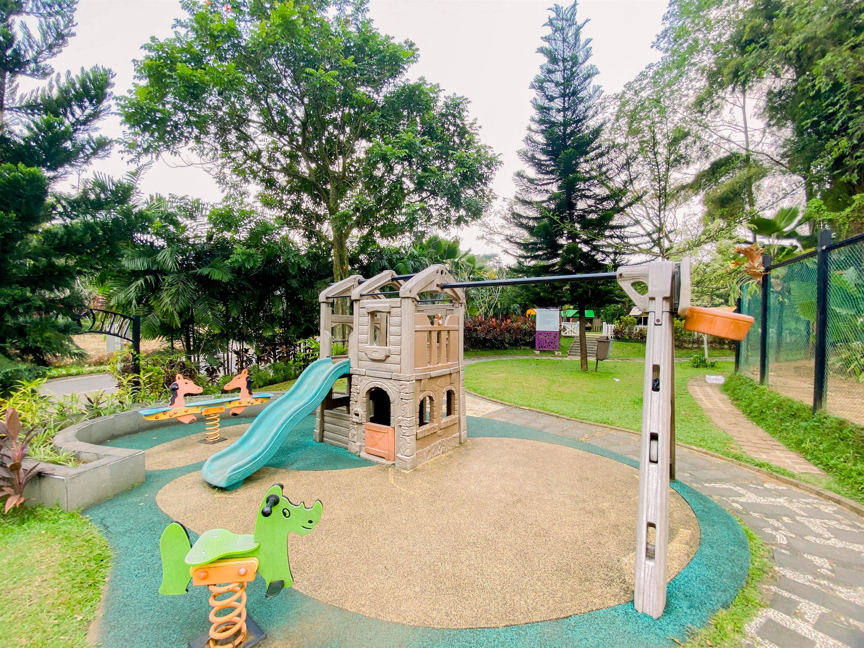 A playground with a slide, climbing structures, and a swing set.