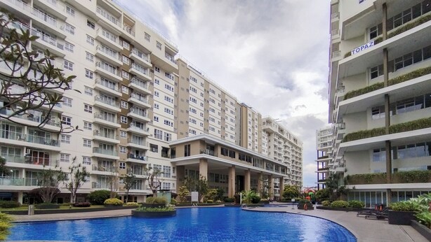 A residential building with multiple balconies and a swimming pool. - Homey Designed 3Br At Gateway Pasteur Apartment (Cimahi)