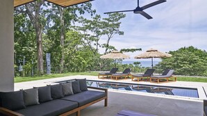 Ein Poolbereich mit einer Couch, Liegestühlen und einem Tisch.