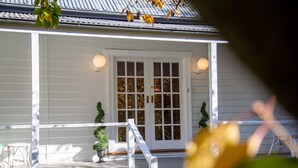 A white house with a front door, two potted plants, and a white railing. - The Foldgarth – late Victorian era farmhouse (Burradoo)
