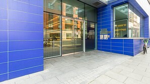 Un edificio moderno con ampie vetrate, facciata blu e una bicicletta parcheggiata all'esterno.