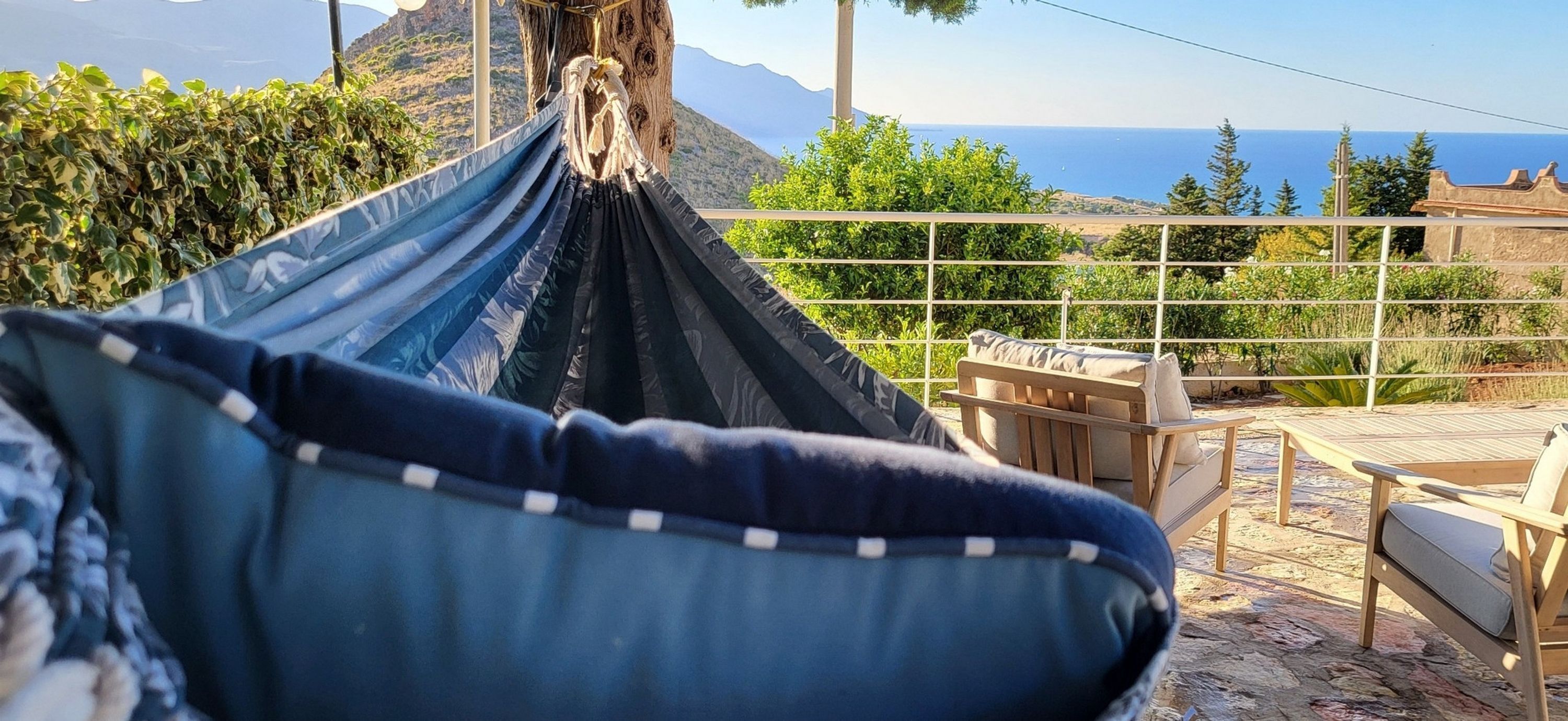 A hammock with a view of the sea and mountains.