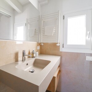 A modern bathroom with a large sink, a mirror, and a window. - Villa Majestatis in Scopello (Castellammare del Golfo)