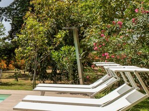A poolside area with lounge chairs and a variety of trees and shrubs. - Giardino di Limoni Eco Friendly Villa (Noto)