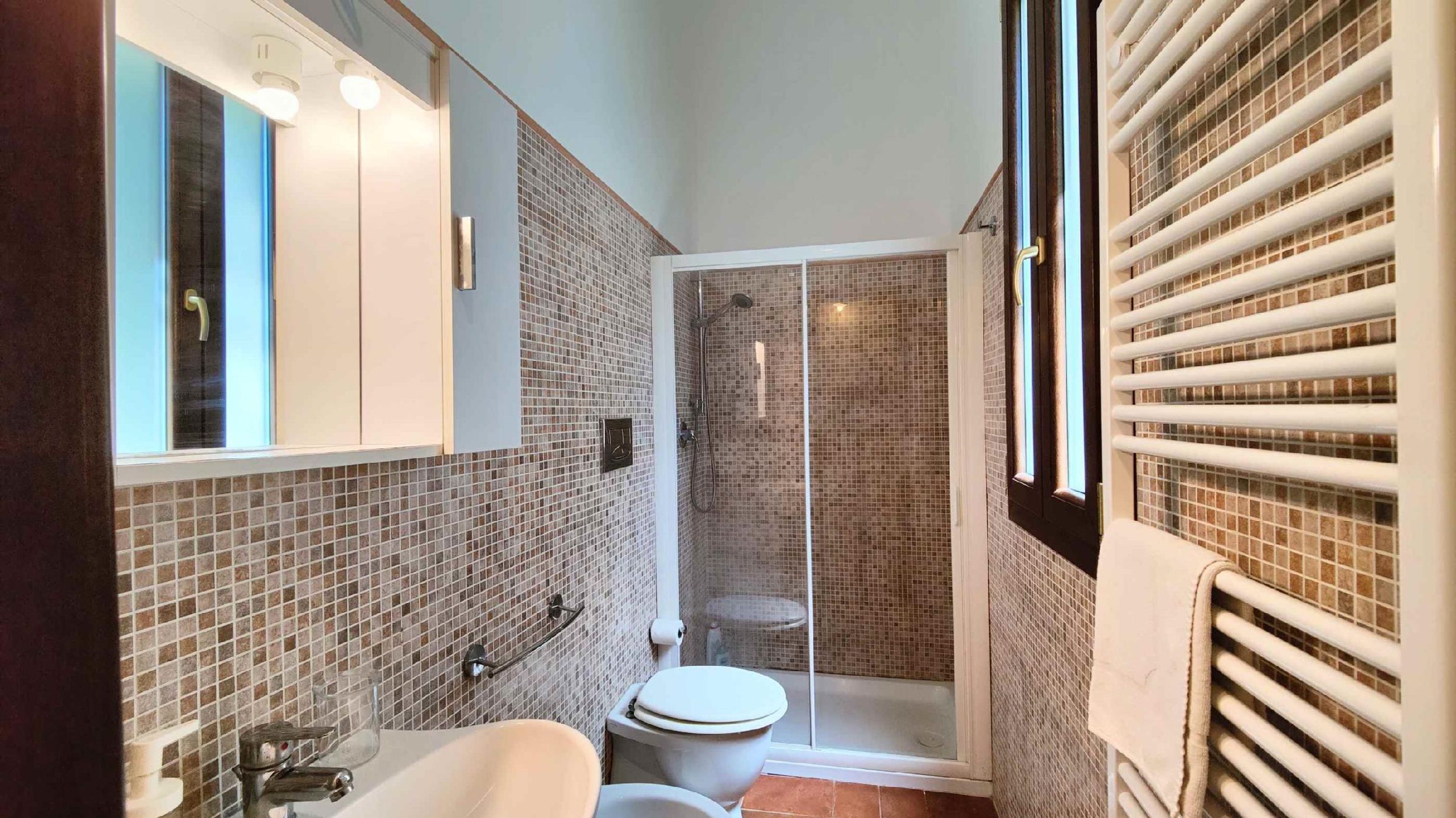 Un baño con ducha, inodoro y lavamanos.