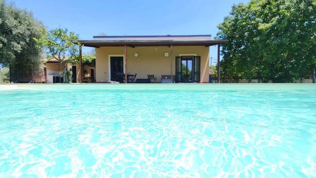 Ein Schwimmbecken mit einem Gebäude im Hintergrund.