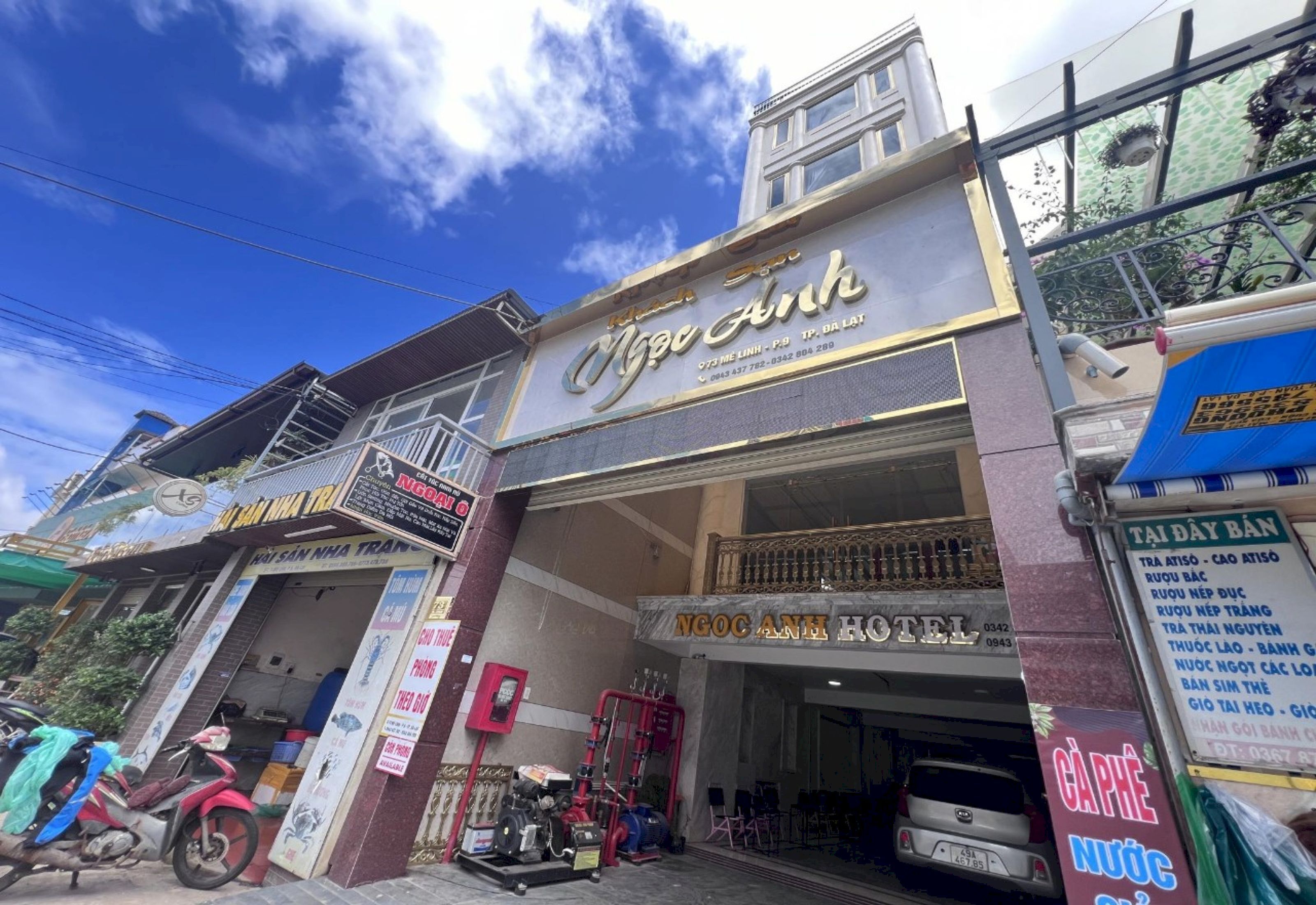 A hotel with a prominent sign, a balcony, and a visible entrance.