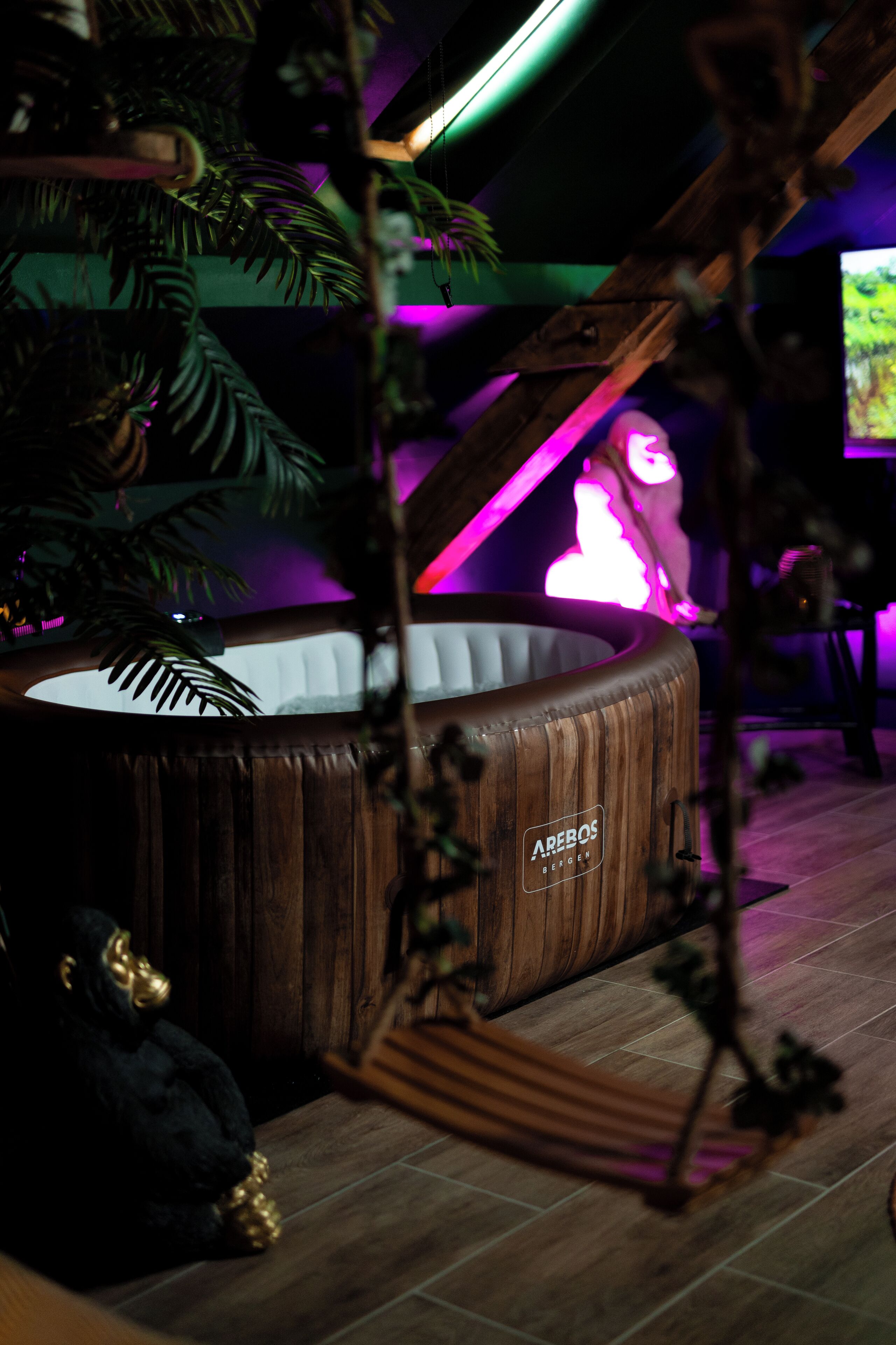 A room with a wooden bathtub, a piano, and a large plant.