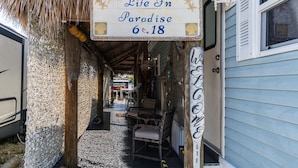 Un étroit sentier mène à un bâtiment sur lequel est apposée une enseigne indiquant : « Life In Paradise 6&18 ».