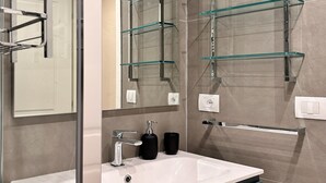 A modern bathroom with a white sink, two black cups, and a mirror. - Modern Apartment in the Heart of Pisa (Pisa)