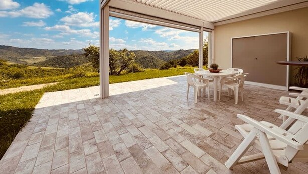 A covered outdoor patio with a view of a hilly landscape. - Villetta Monte San Lorenzo (Monte San Pietro)