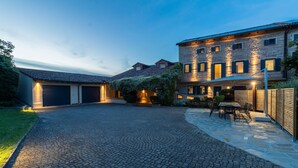 Une grande maison à deux étages, dotée d’une allée pavée et d’un espace patio.