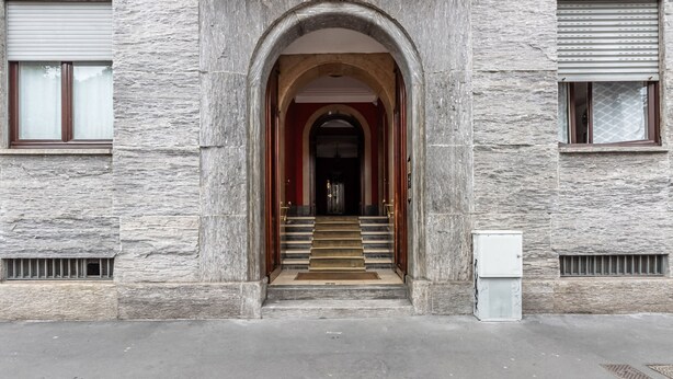 Un edificio in pietra con un arco centrale che conduce a una scala.