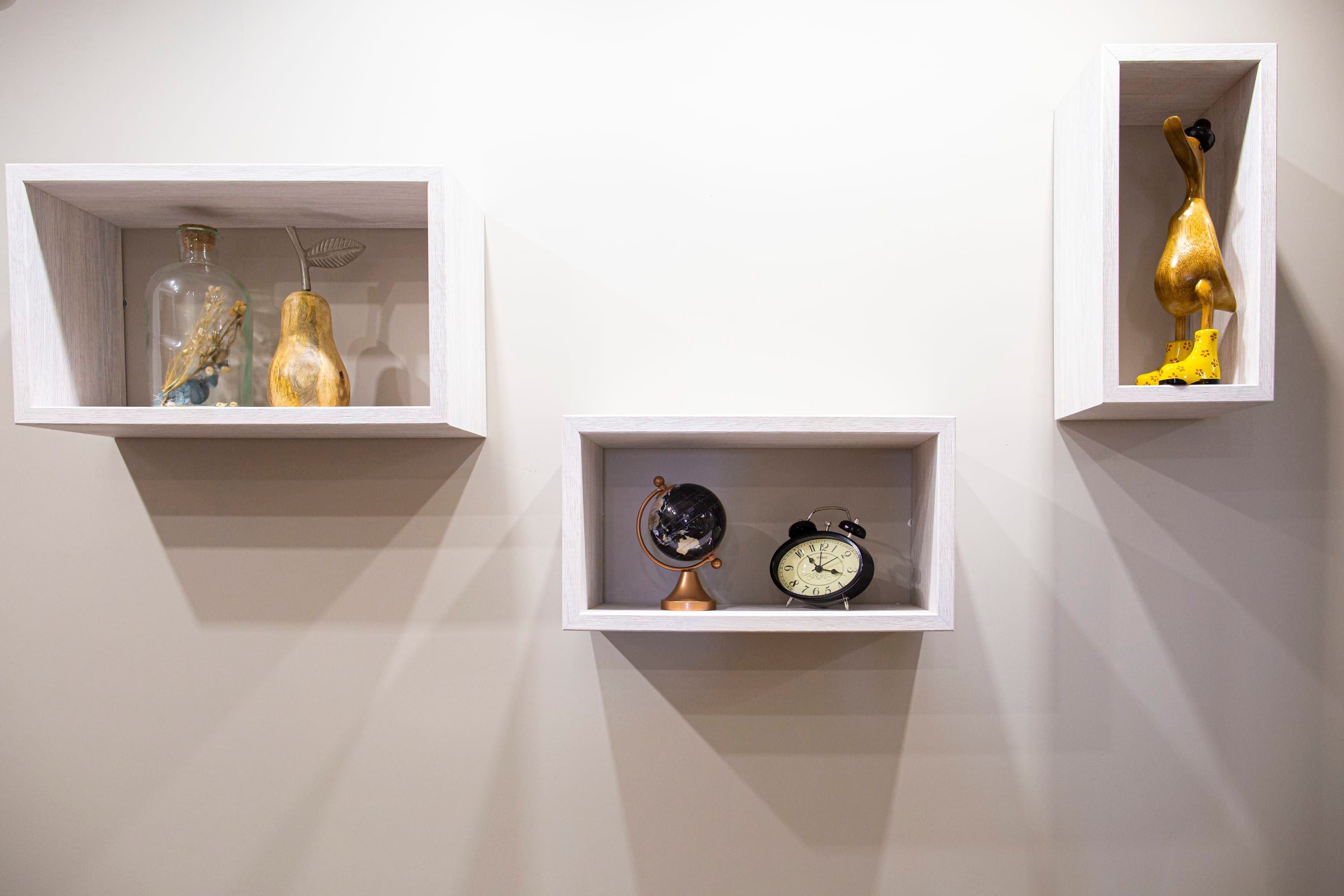 Three white display cases with various objects.