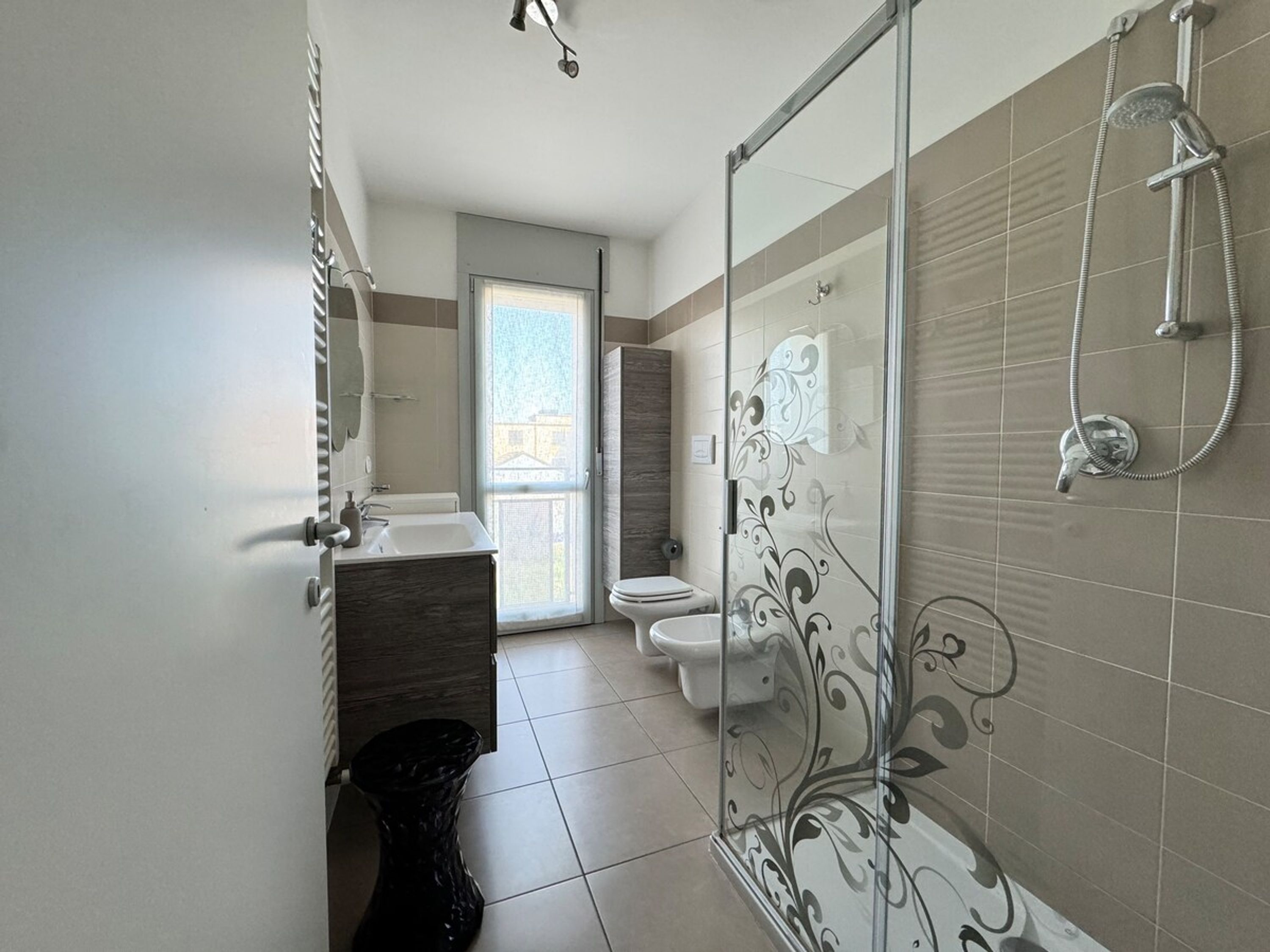 Ein modernes Badezimmer mit Duschkabine, Toilette und Waschbecken mit Spiegel.