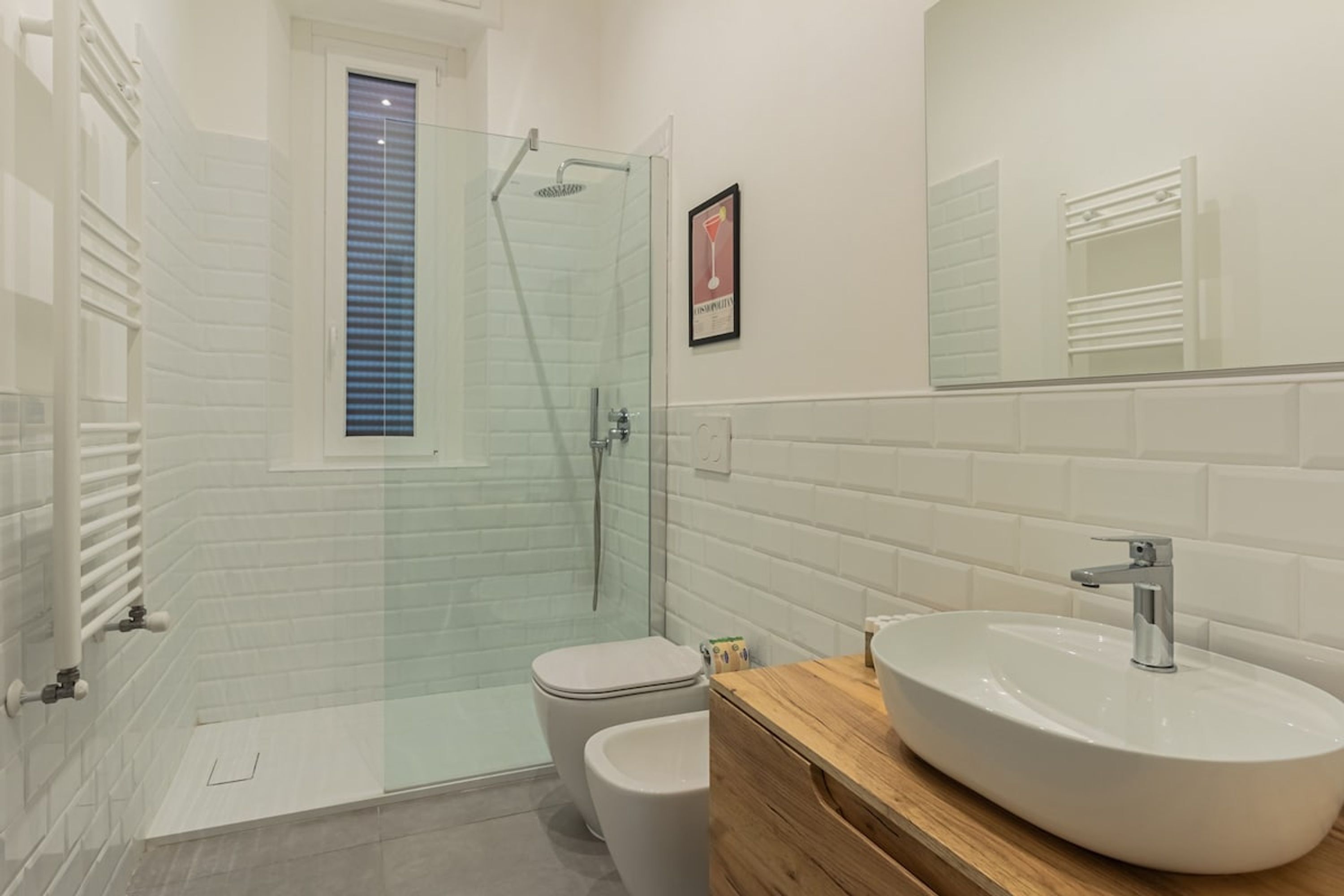 Ein modernes Badezimmer mit einer Duschkabine, einer weißen Toilette und einem Holzausleger mit Waschbecken.