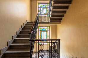 A staircase with a handrail and a stained glass window at the top. - Dimora Soperga Freshly Designed and Spacious (Milan)