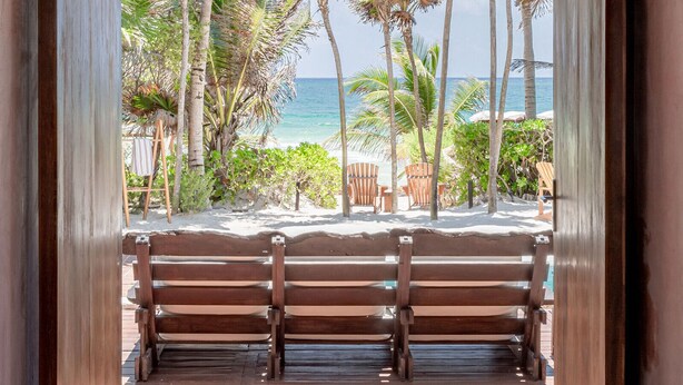 A wooden bench area with a view of the beach and ocean. - ANANA Casa Cantarena (Tulum)