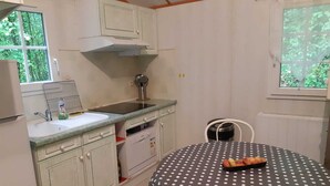 Eine kleine Küche mit Spüle, Herd und einem Tisch mit Punkten.