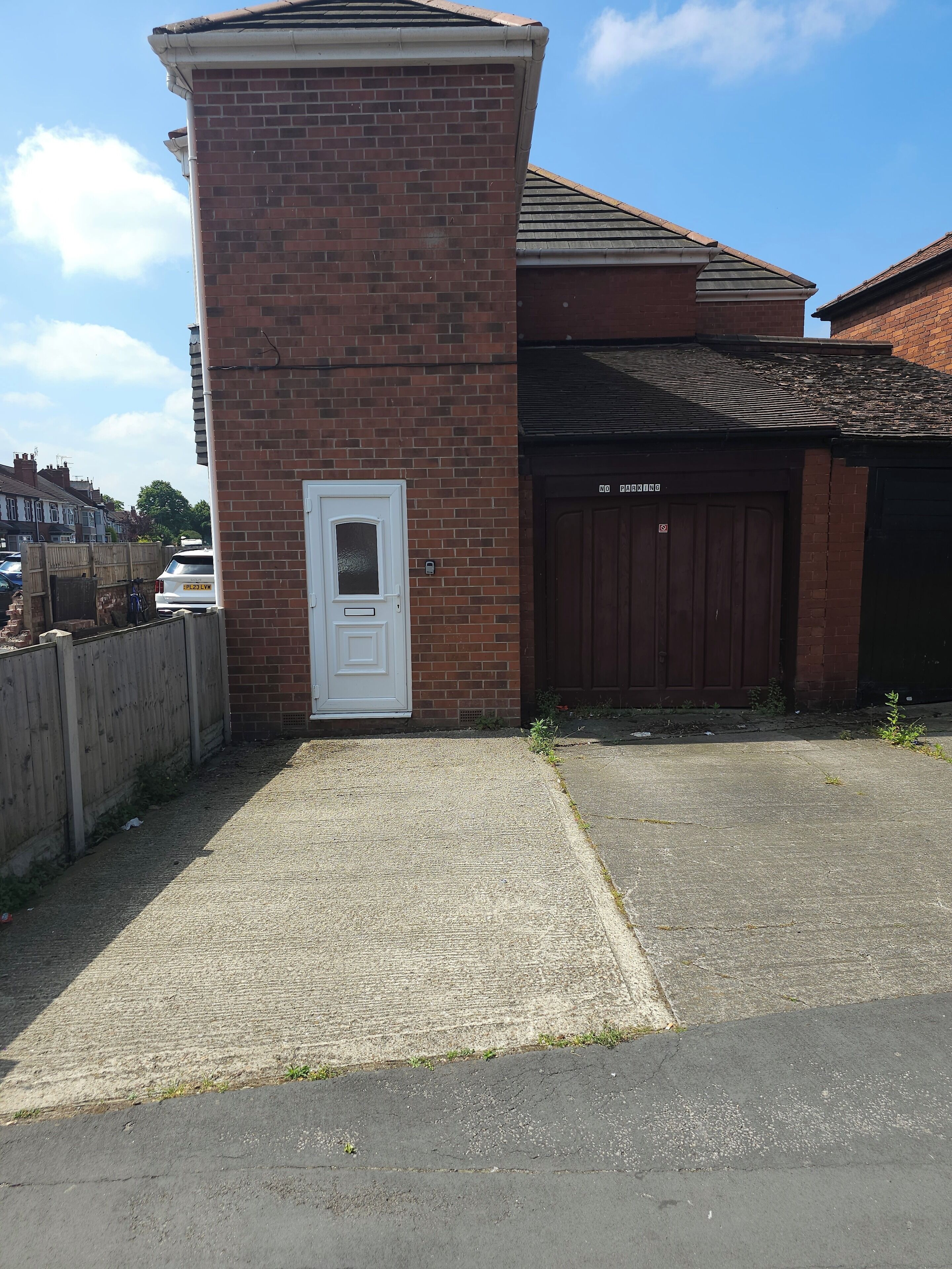 Un bâtiment en briques avec une porte blanche et une porte de garage.