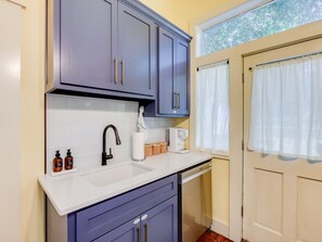 A kitchen with a white countertop, a sink, a coffee maker, and cabinets. - Little Acres: 2 Bedroom Near Hospitals (Augusta)