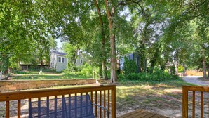A wooden deck with a bench, surrounded by trees and a grassy yard. - Little Acres: 2 Bedroom Near Hospitals (Augusta)
