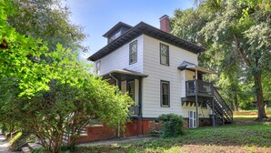 A two-story house with a balcony and a chimney. - Sand Hills: Medical District, Historic Summerville (Augusta)