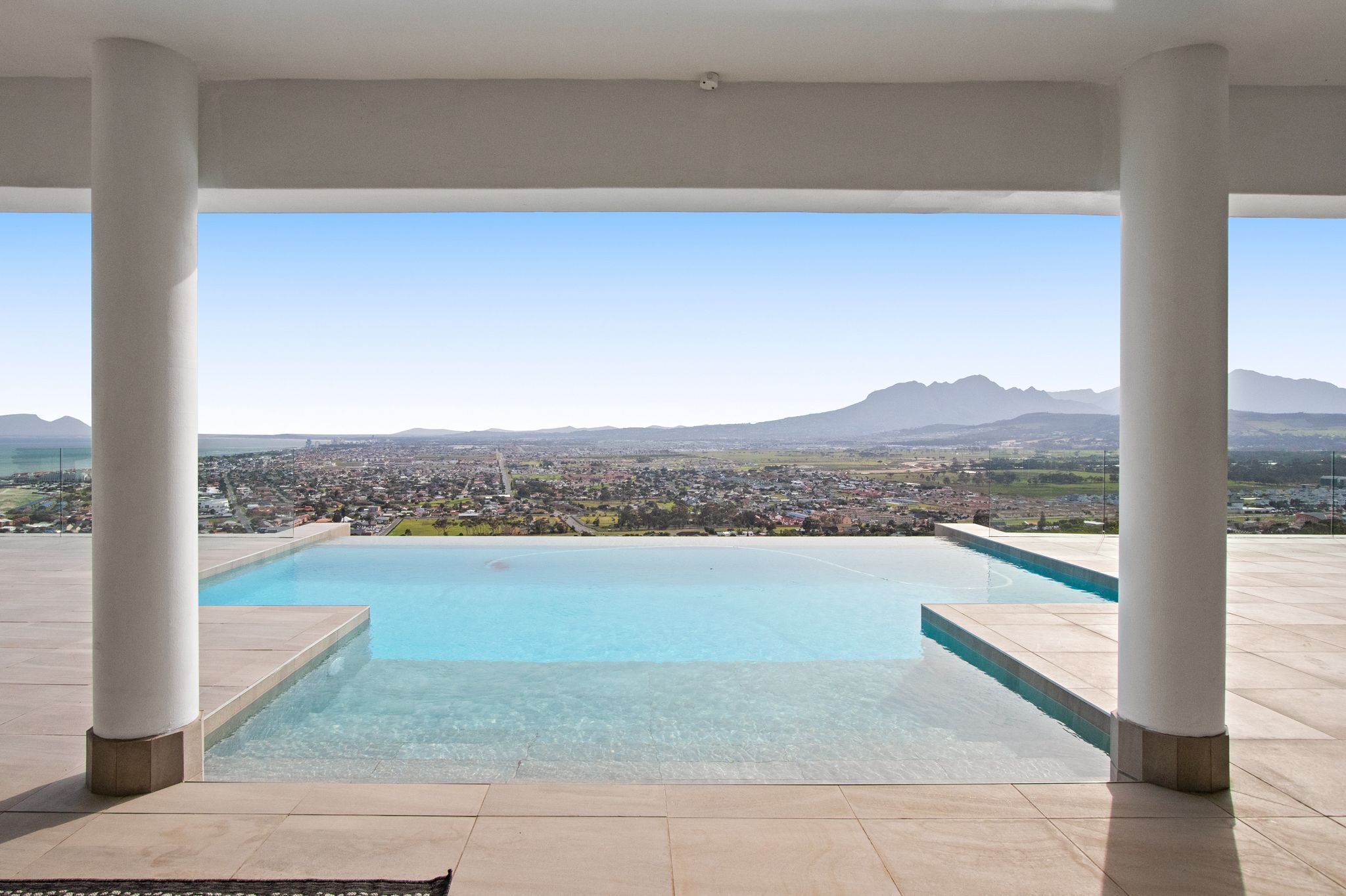 A pool with a clear view of a cityscape and mountains in the distance.