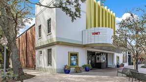 A cinema with a modern design, featuring a prominent 'TENET' sign.