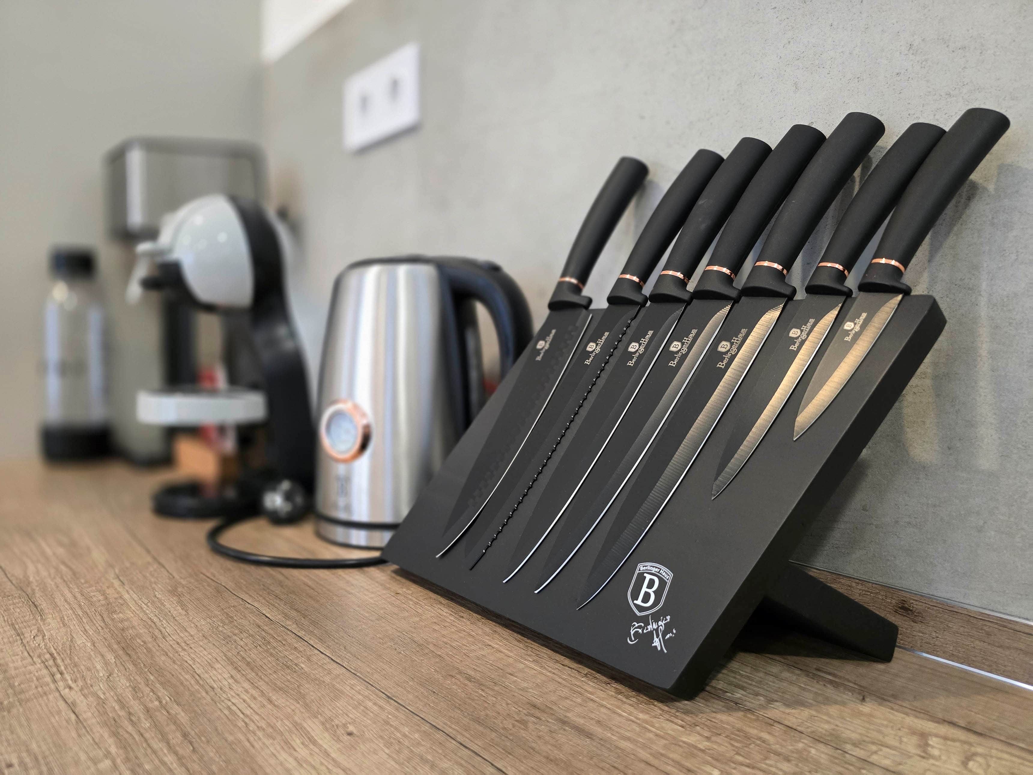 Eine Küchenarbeitsplatte mit einem Messerblock, der mehrere Messer, einen Wasserkocher und eine Kaffeemaschine enthält.